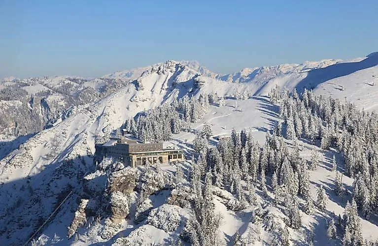 Paesaggio invernale innevato con hotel di montagna sul Predigtstuhl, vicino a Bad Reichenhall, alla luce del sole