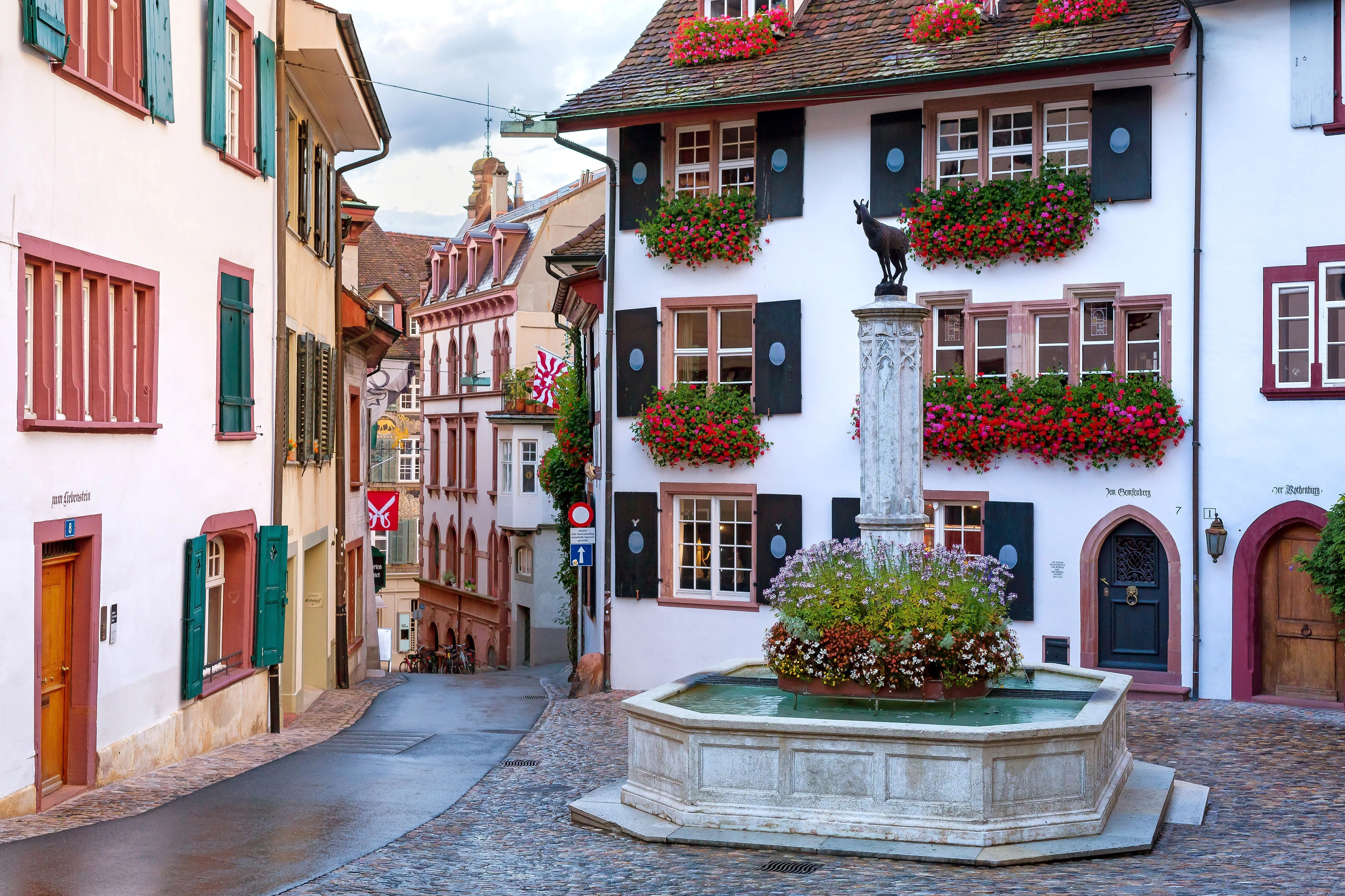 Historischer Platz Am Gemsberg in Basel mit Ziegenbrunnen und blumengeschmückten Fassaden