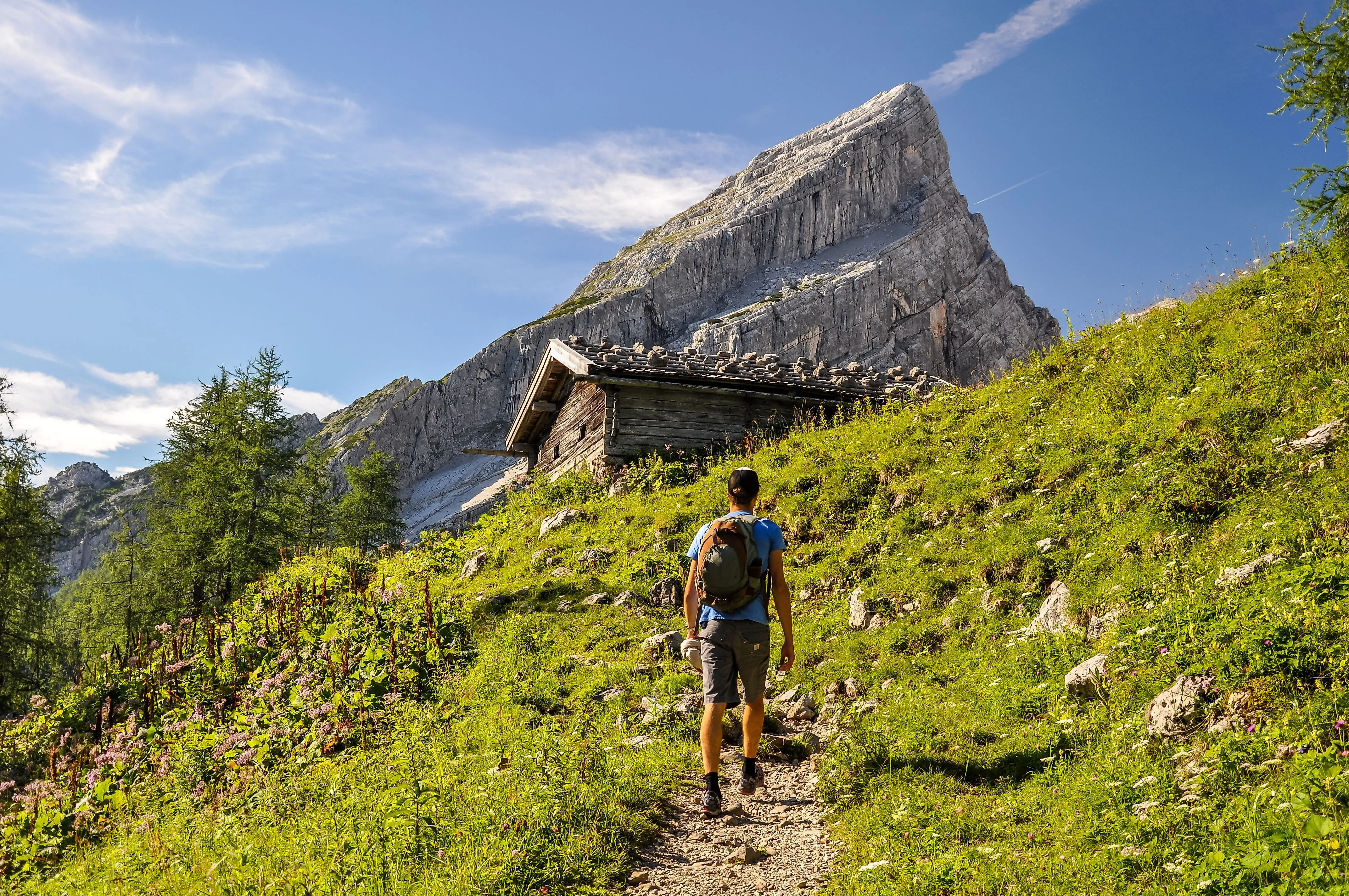 Wanderer auf einem Gebirgspfad am Watzmann-Massiv bei Berchtesgaden an einem sonnigen Sommertag.