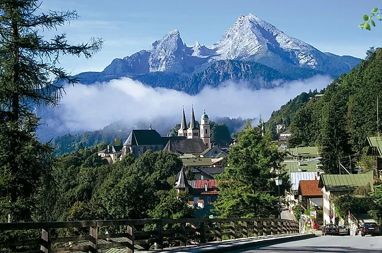 Blick auf den historischen Ortskern von Berchtesgaden mit Kirchen und dem Watzmann im Hintergrund.