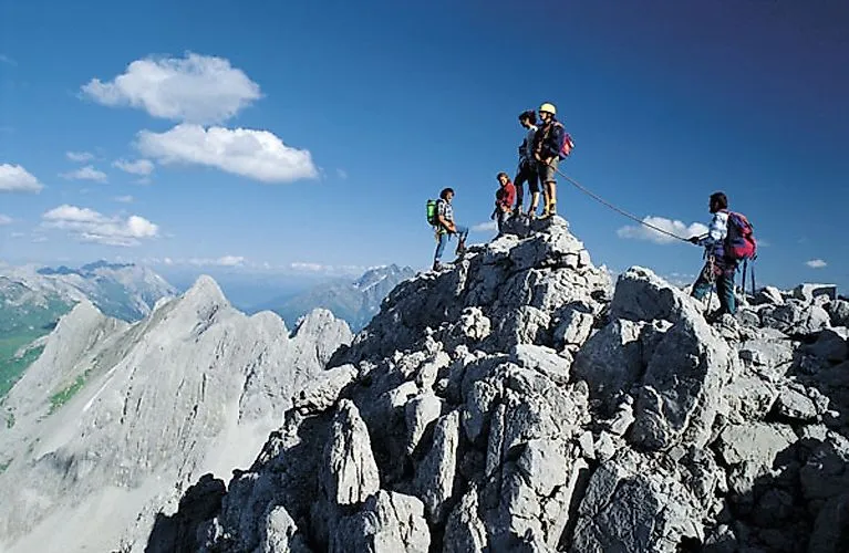 Il gruppo si arrampica sulla cima rocciosa vicino a St. Anton am Arlberg con vista sulle montagne
