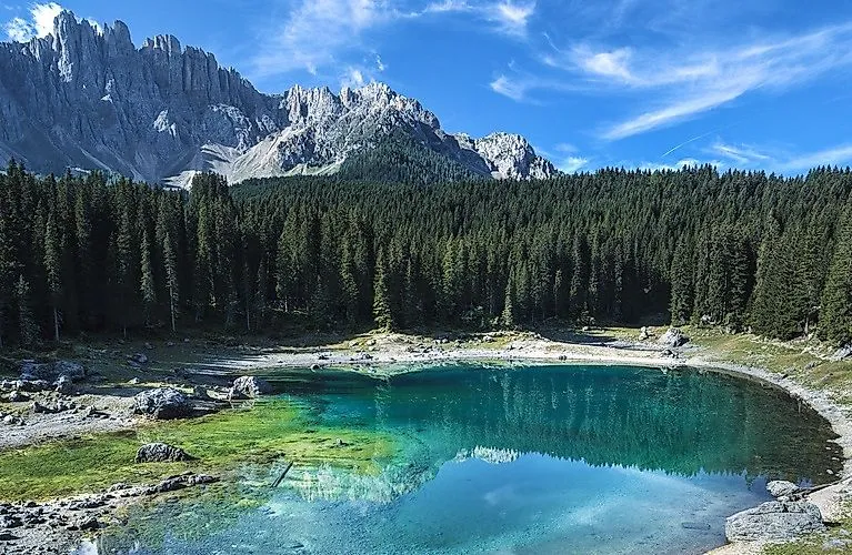 Uitzicht op het meer van Carezza met de Dolomieten weerspiegeld in het heldere water