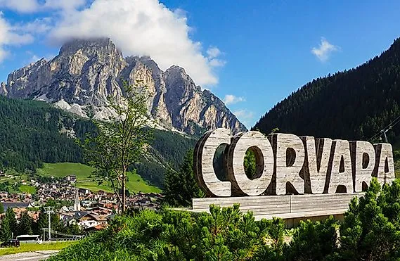 Uitzicht op het dorp Corvara in de zomer, omringd door groene weiden en de indrukwekkende toppen van de Dolomieten.