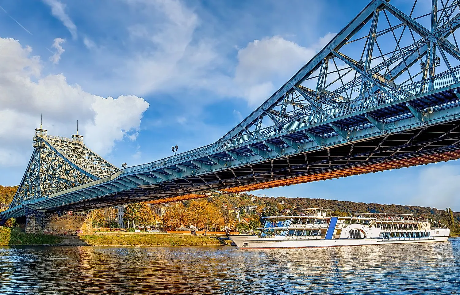 Die Brücke Blaues Wunder in Dresden mit Ausflugsschiff auf der Elbe, herbstlicher Uferkulisse und Blick auf die Hänge von Loschwitz