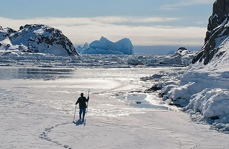 Wanderung auf vereister Bucht mit Eisbergen in Ostgrönland