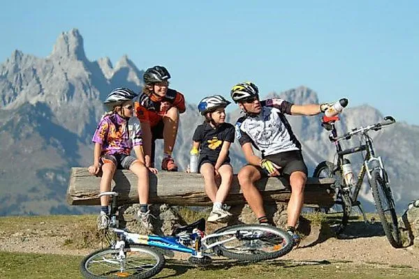 Familie beim Mountainbiken mit Blick auf die Berge bei Radstadt im Sommer.