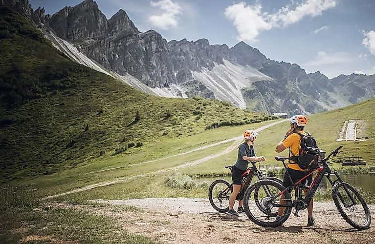 Twee mountainbikers nemen een pauze voor een indrukwekkende rotsachtige achtergrond in de buurt van Gossensass in Zuid-Tirol.
