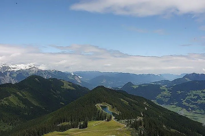 Blick auf das Spieljoch bei Fügen mit grünen Almen, Wäldern und Fernsicht auf die Zillertaler Alpen.
