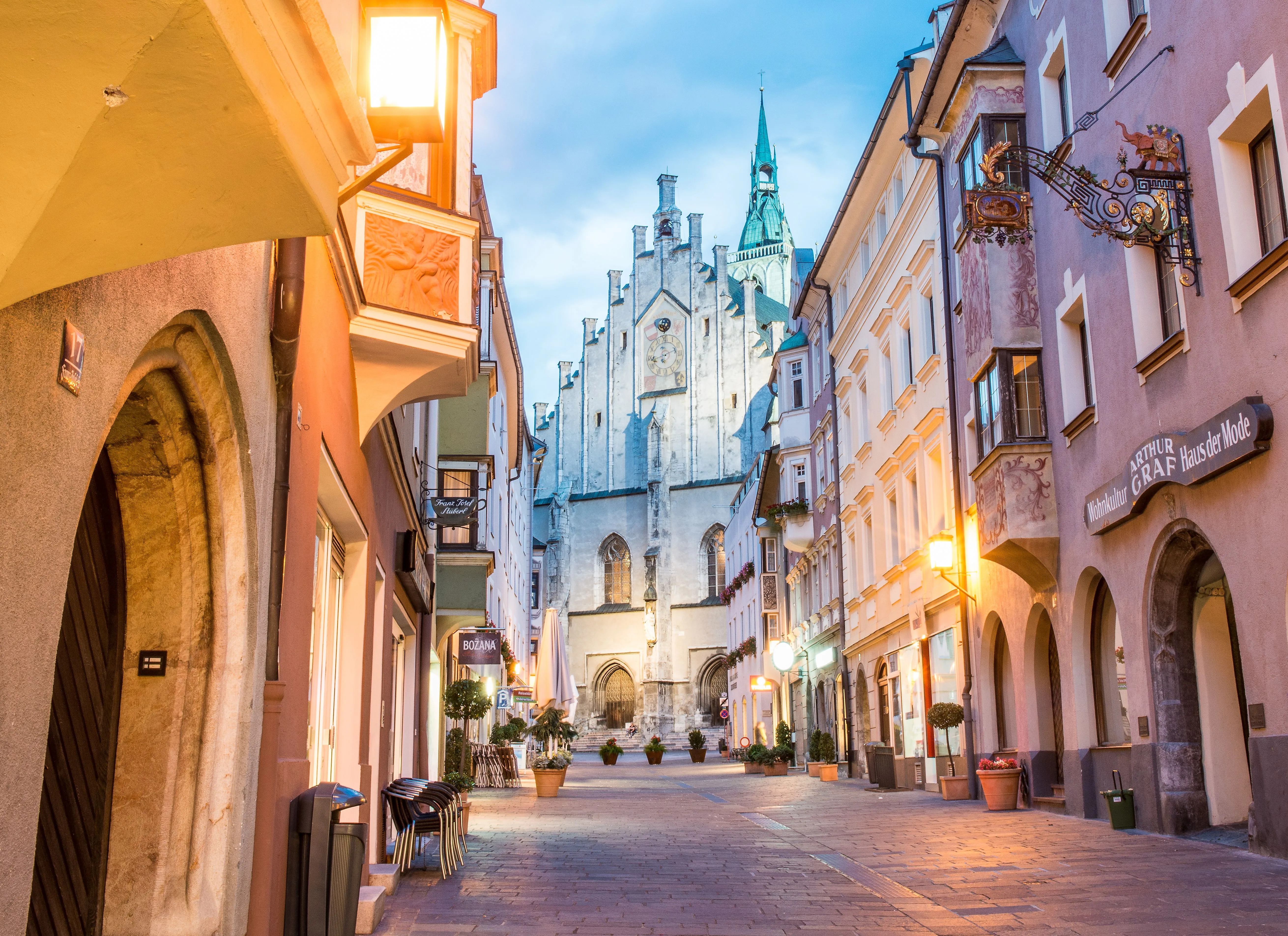 Historische Altstadtgasse in Schwaz mit Pfarrkirche und stimmungsvoller Beleuchtung am Abend