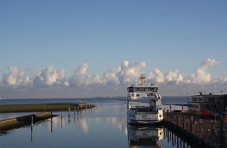 Fähre im Hafen von Norden-Norddeich vor blauem Himmel und ruhigem Meer an einem klaren Tag.