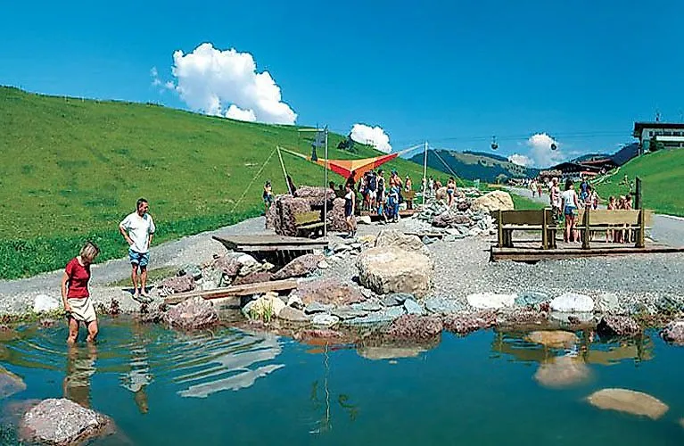 Kinder plantschen im Wasser und erkunden spielerisch die Natur in der Erlebniswelt Hexenwasser in der SkiWelt Wilder Kaiser im Sommer.