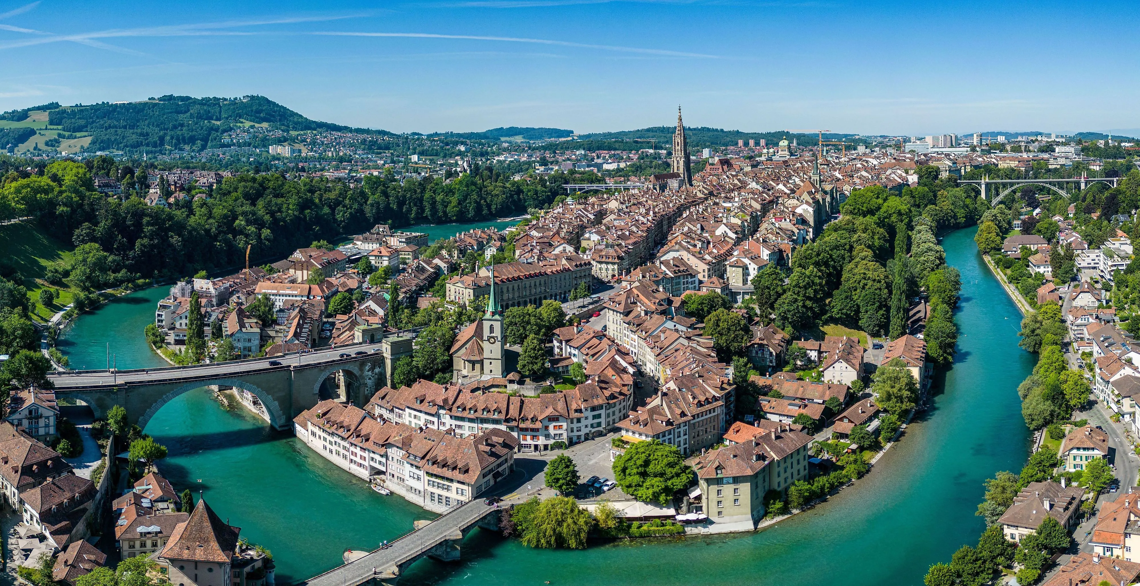 UNESCO-Altstadt von Bern mit Berner Münster und Aareschleife an einem klaren Sommertag.