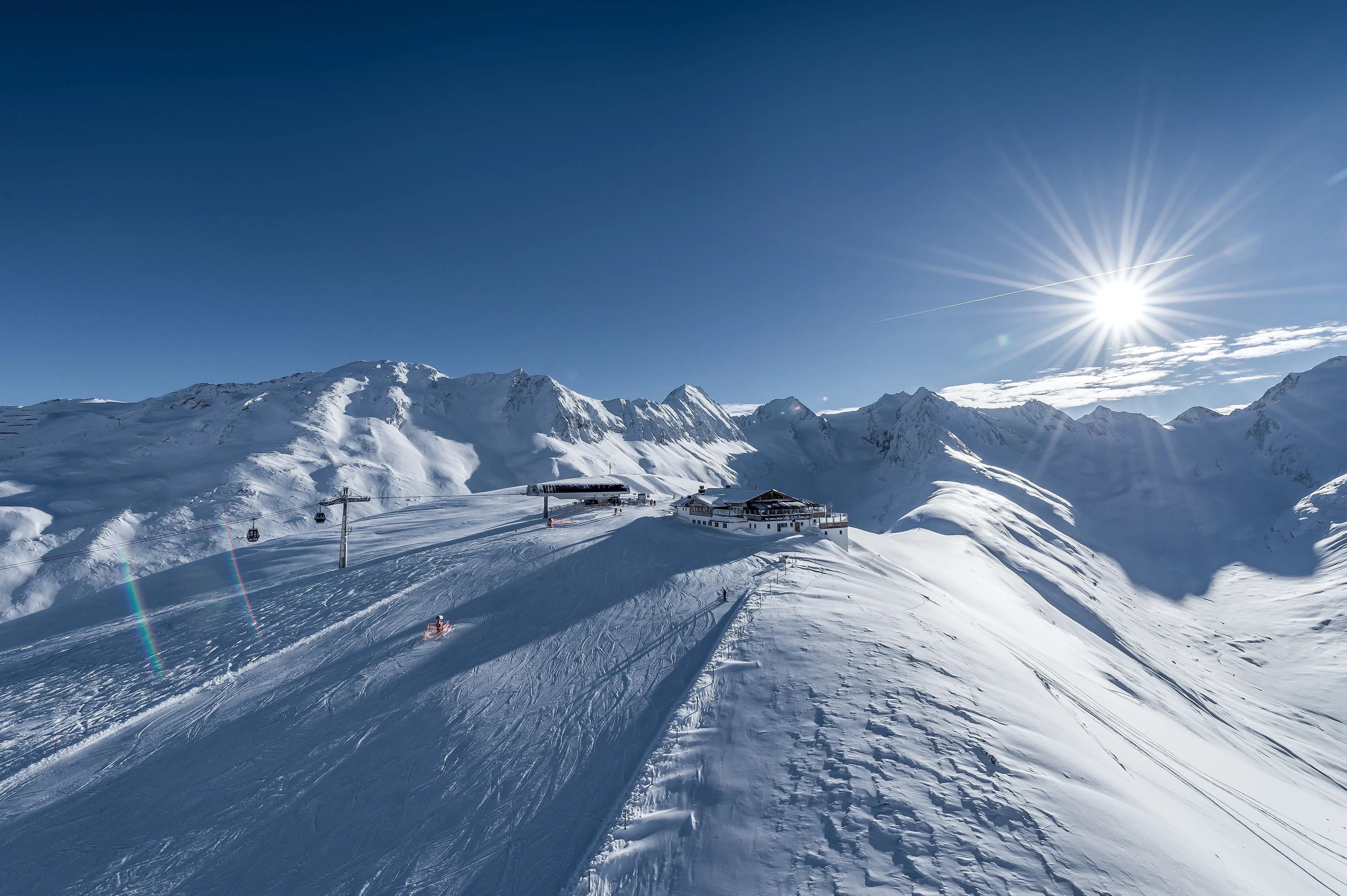 Panoramaaufnahme vom Skigebiet Hohe Mut in Gurgl mit glitzernden Schneehängen und Sonnenschein im Ötztal