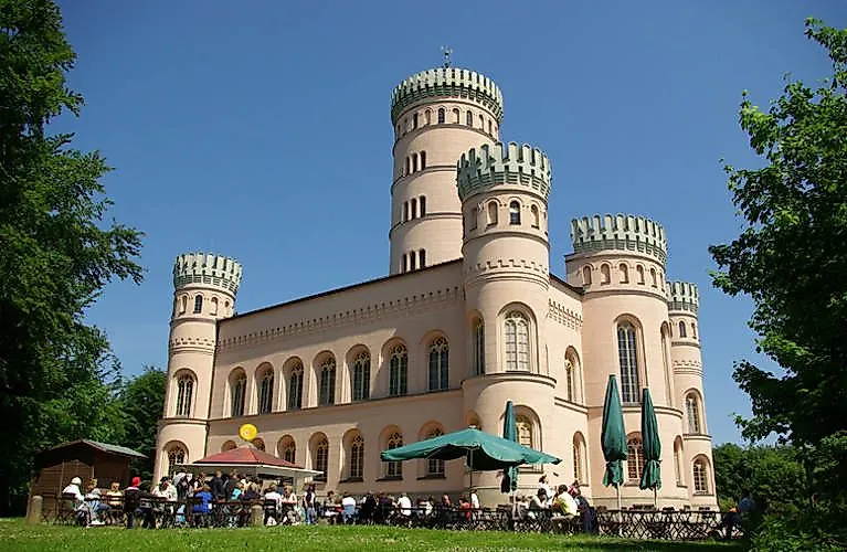 Historisches Jagdschloss Granitz bei Binz auf Rügen mit markanten Rundtürmen und Außengastronomie an einem Sommertag