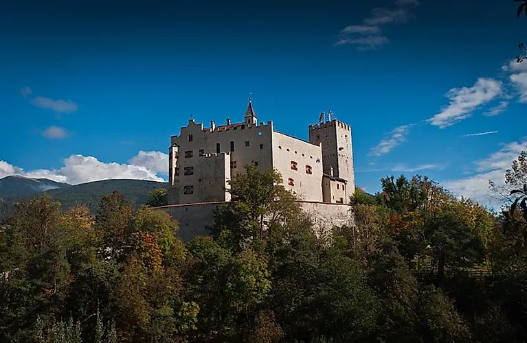 Kasteel Bruneck in Zuid-Tirol op een beboste heuvel boven de stad in het Pusterdal