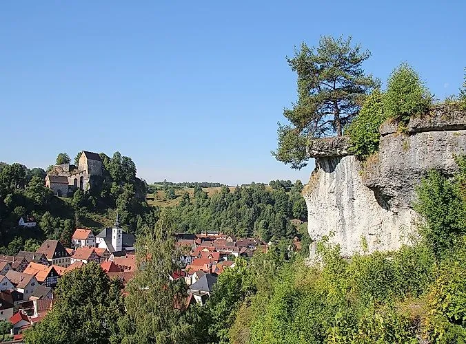 View of the historic Pottenstein Castle in the middle of a green landscape in Franconia