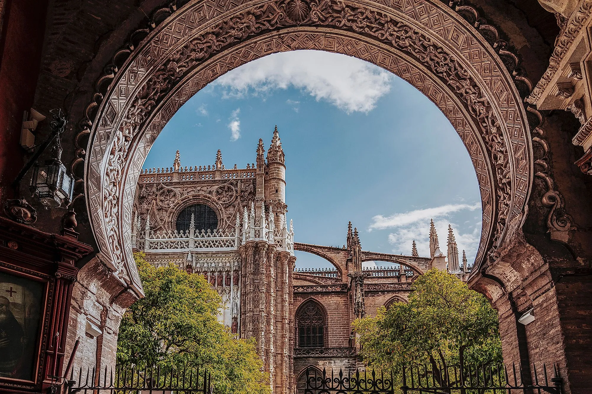 Gotische Kathedrale von Sevilla mit kunstvoll verziertem Bogen und blauem Himmel