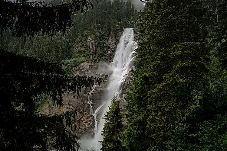 Krimmler Wasserfälle im Nationalpark Hohe Tauern, hoher Wasserfall zwischen dichten Nadelwäldern in den österreichischen Alpen