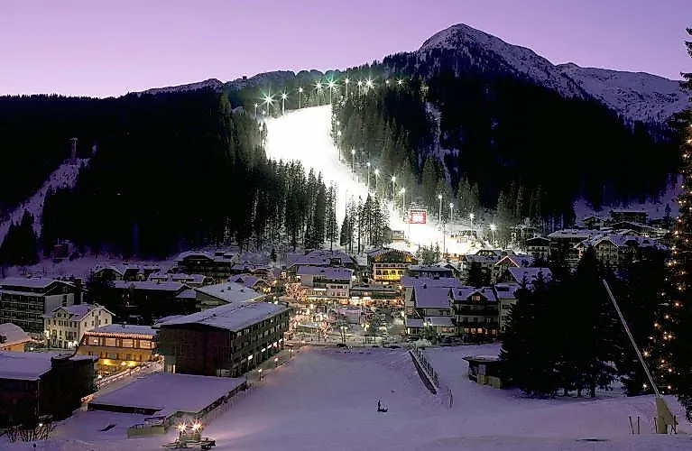 Eine beleuchtete Skipiste in der Nacht in Madonna di Campiglio in Italien. 