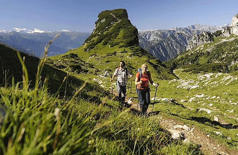 Zwei Wanderer auf einem schmalen Bergpfad im Rofangebirge bei Maurach mit weitem Alpenblick.