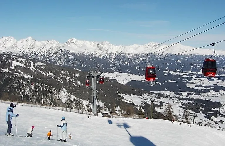 Skifahrer und rote Gondeln Skigebiet Grosseck-Speiereck in der Region Mauterndorf