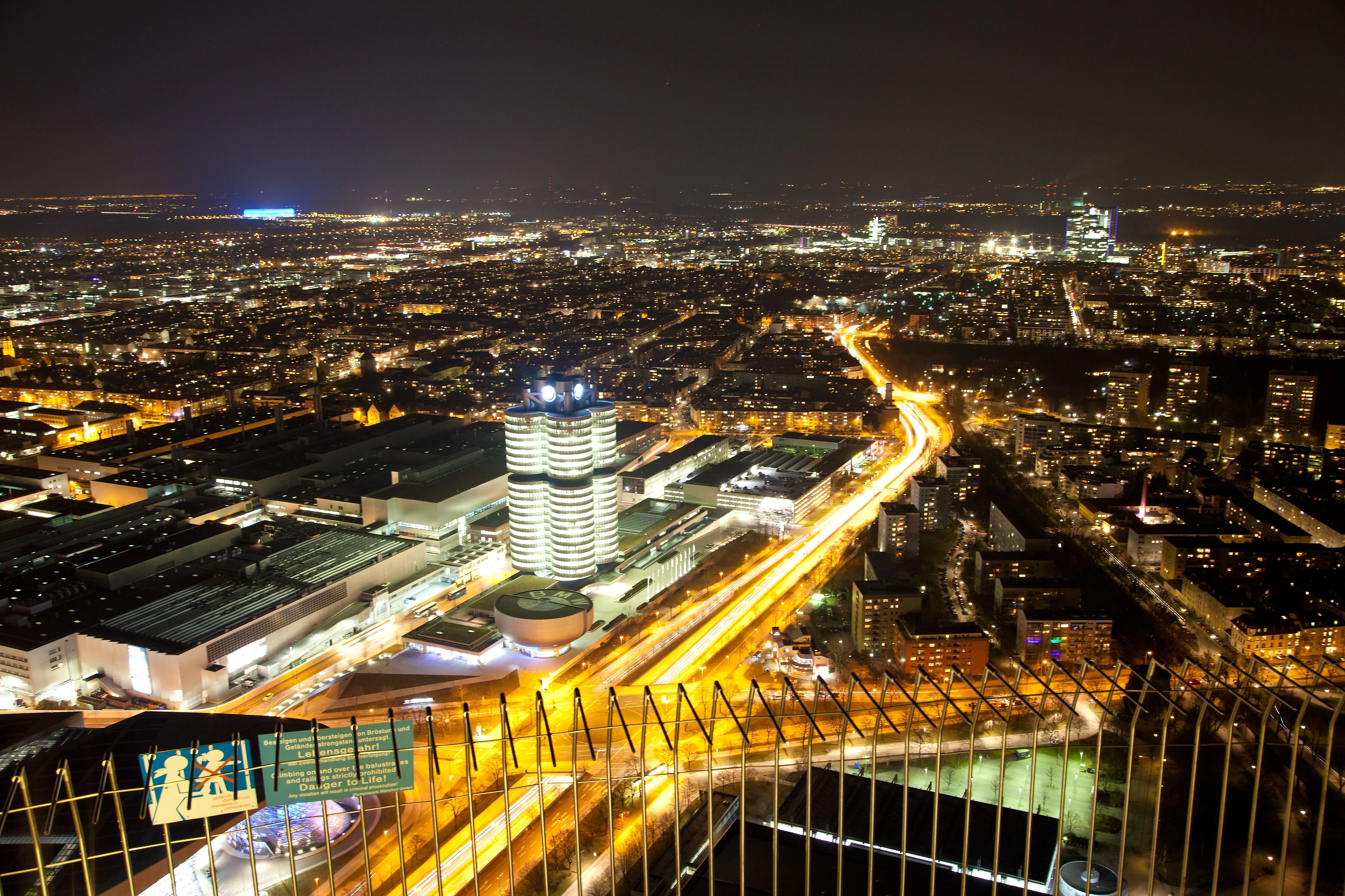 München bei Nacht mit der leuchtenden Allianzarena im Hintergrund