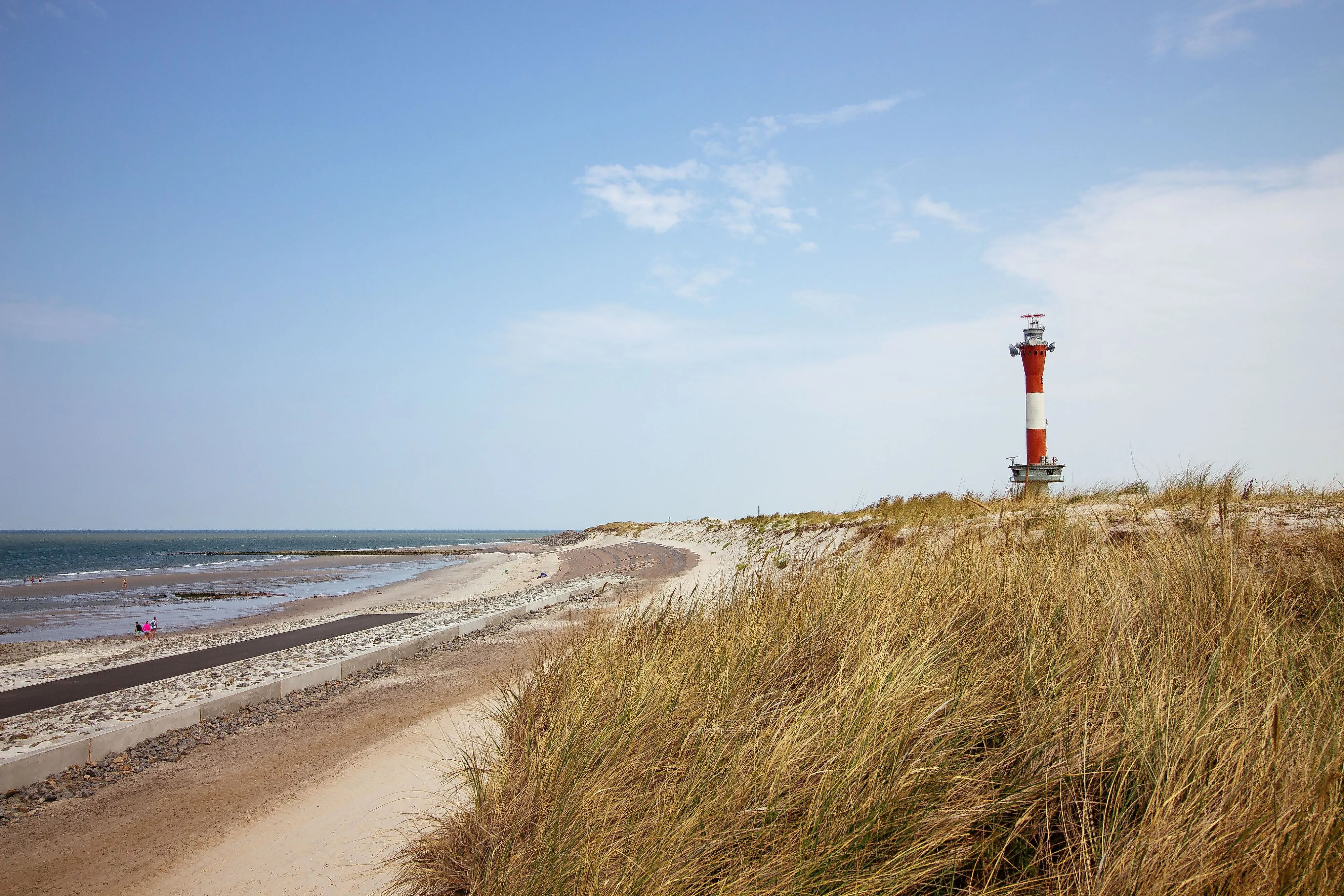 Leuchtturm auf Wangerooge hinter Dünen mit Blick auf Strand und Nordsee