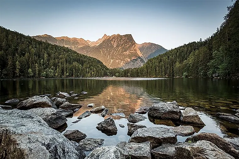 Reflejo del macizo montañoso en el tranquilo lago Piburger See al atardecer en el Ötztal tirolés.