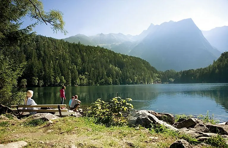 Familie genießt die Sommeridylle am Piburger See in Oetz mit Blick auf bewaldete Berge und klares Wasser.