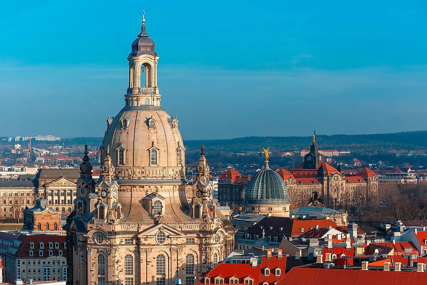 Nahaufnahme der barocken Frauenkirche Dresden bei klarem Himmel mit Blick auf umliegende Altstadtdächer und Kuppeln