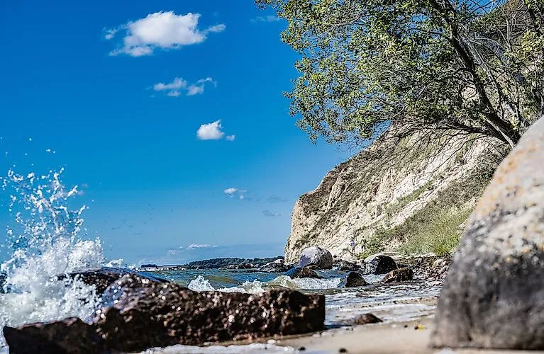 Wellen schlagen gegen die Felsen an der naturbelassenen Steilküste von Mönchgut auf Rügen.