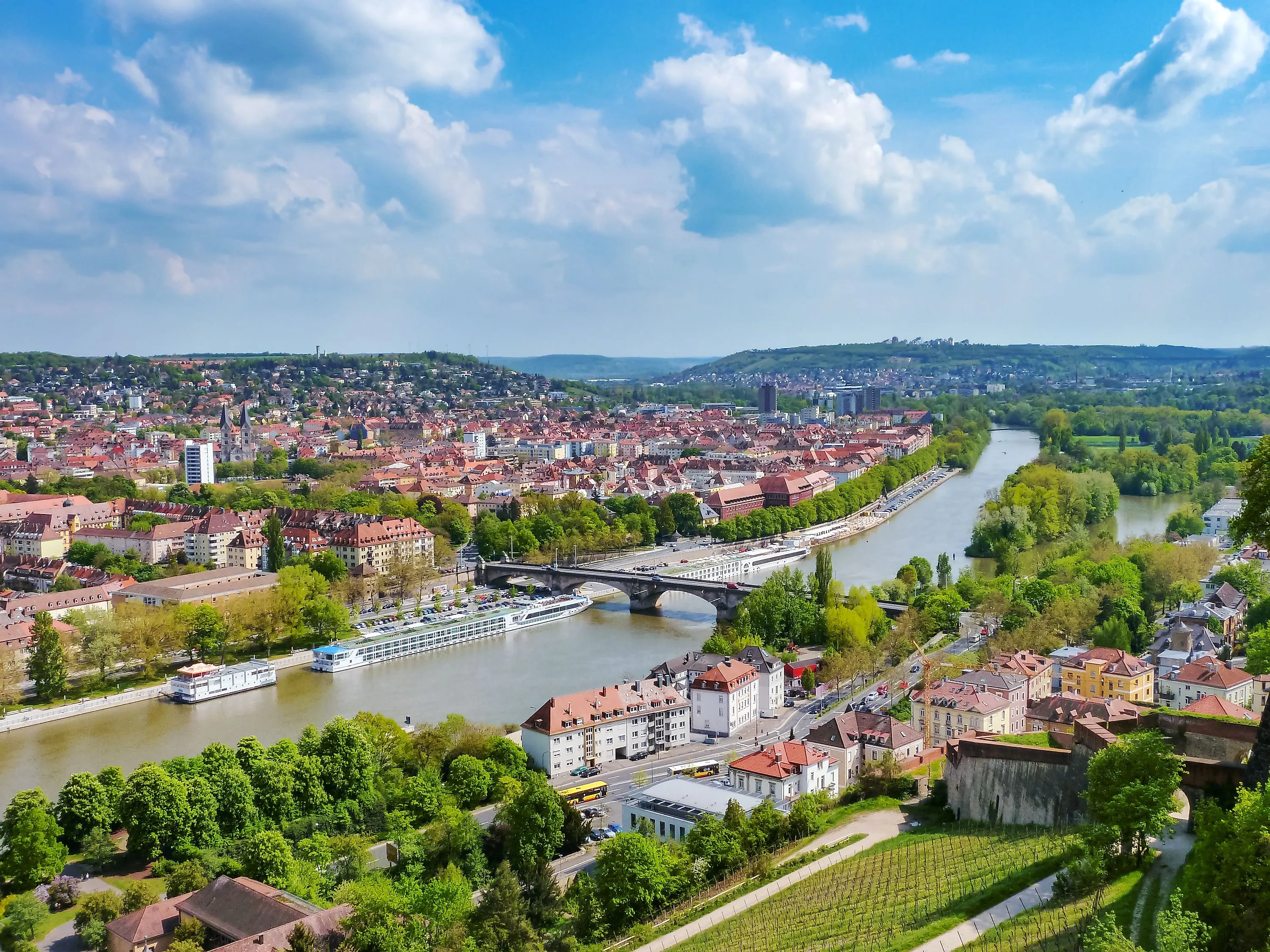 Panoramablick über Würzburg mit dem Main und einem Flusskreuzfahrtschiff im Sommer.