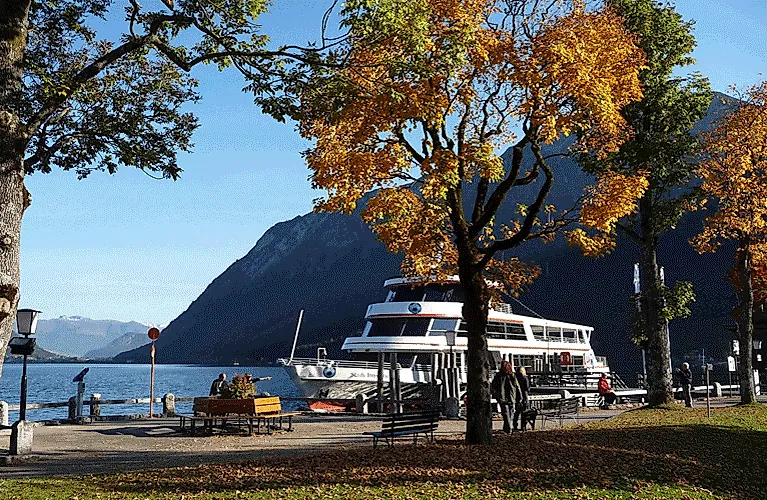 Herbstliche Stimmung am Ufer des Achensees in Pertisau mit einem Ausflugsschiff an der Anlegestelle.