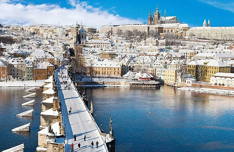 Verschneite Karlsbrücke in Prag mit Blick auf die Prager Burg und die Altstadt im Winter