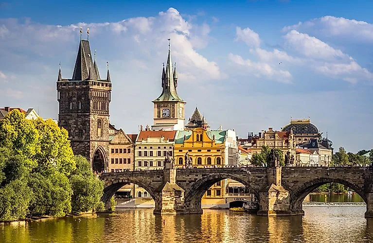 Sommerlicher Blick auf die Karlsbrücke in Prag mit historischem Brückenturm und Altstadthäusern bei blauem Himmel