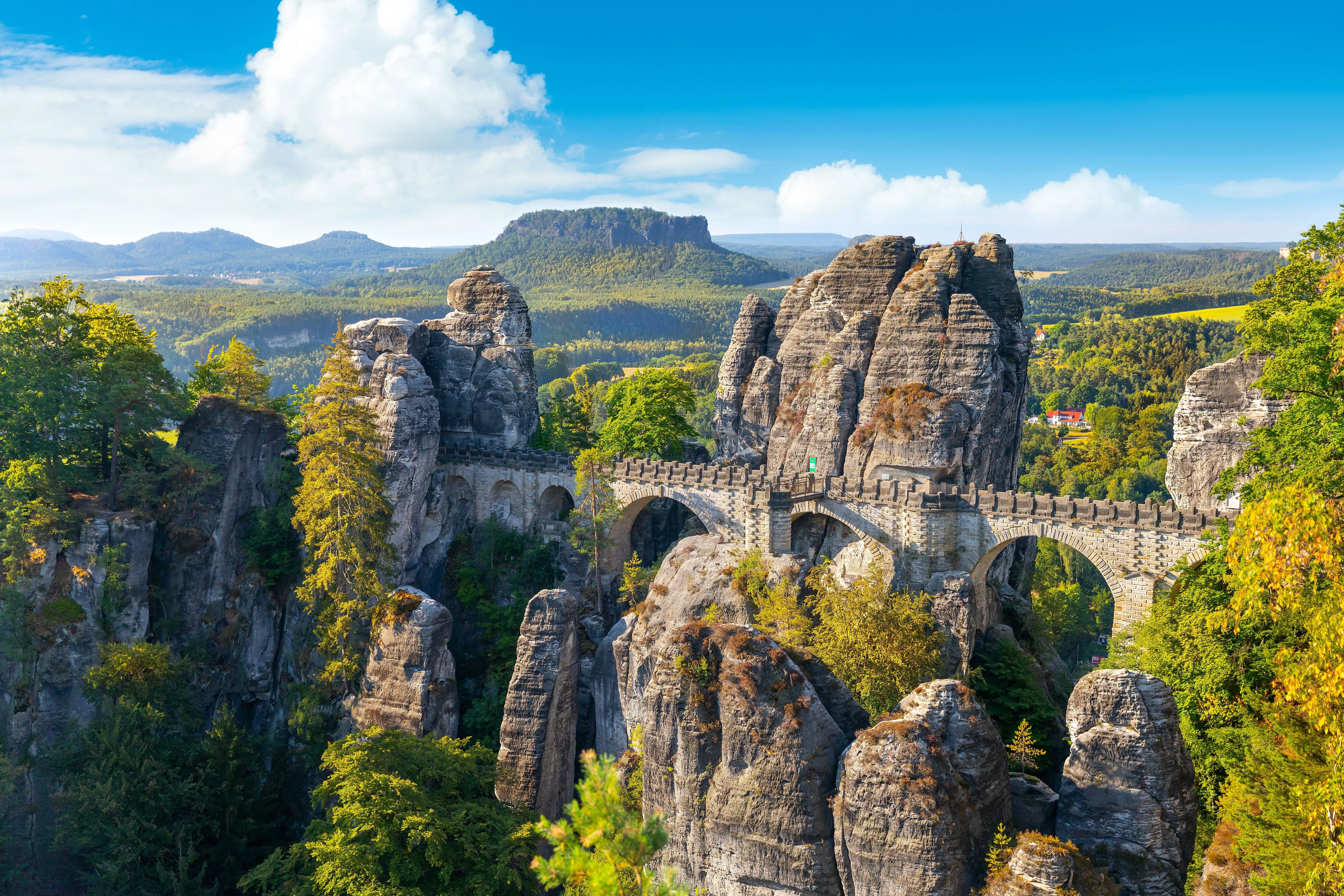 Die berühmte Basteibrücke in der Sächsischen Schweiz überspannt majestätisch die imposanten Sandsteinfelsen bei Rathen an einem klaren Sommertag.