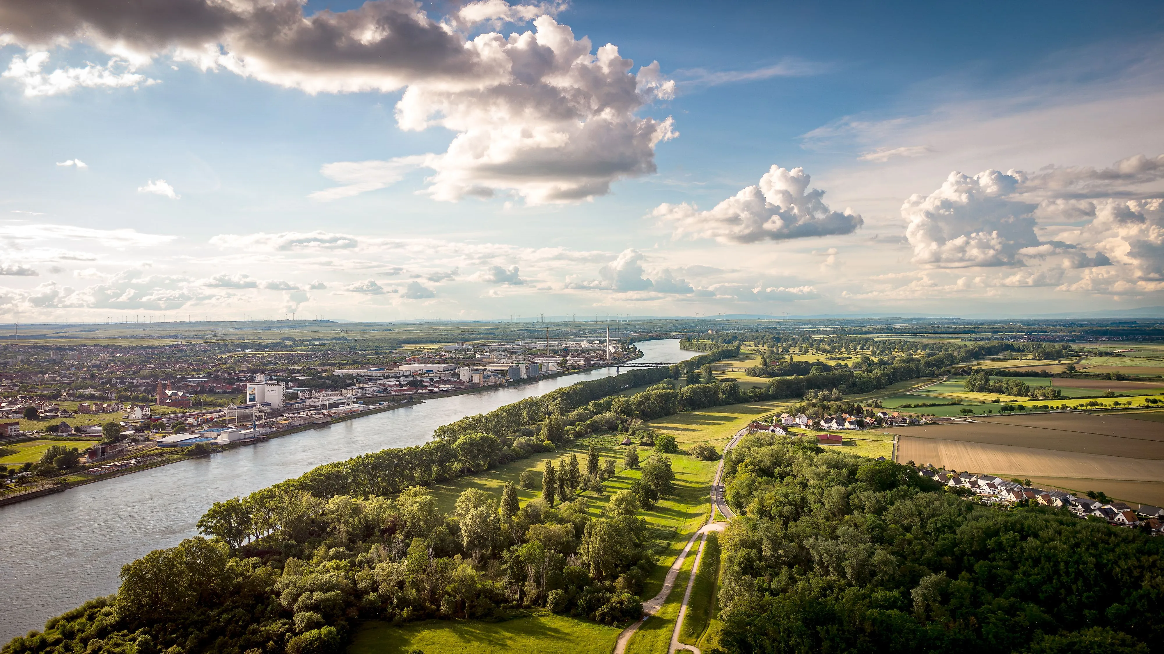 Weitläufiges Panorama des Rheintals bei Worms mit Flusslauf, Feldern und Ortschaften.