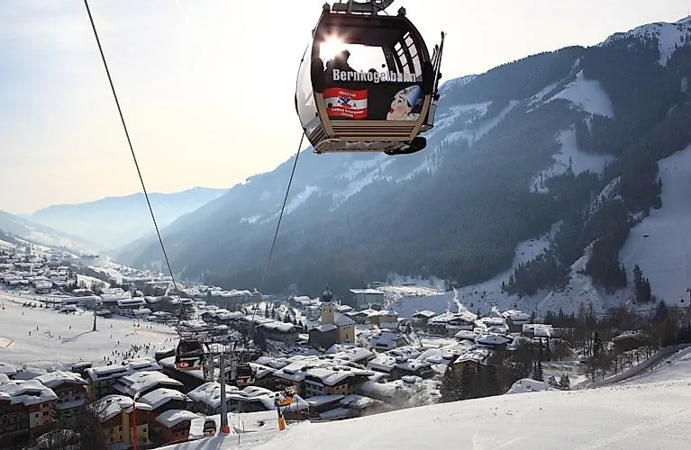 Vista invernale di Saalbach con i tetti innevati e la funivia del Bernkogel in primo piano.
