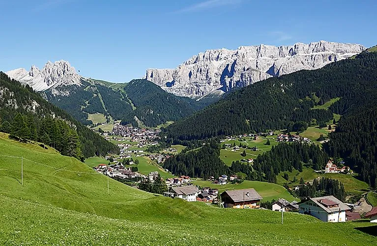 Selva di Val Gardena in de zomer met groene weiden en de Dolomieten op de achtergrond