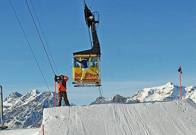 Luftseilbahn über Schneepiste im Skigebiet Bormio mit Blick auf die verschneiten Alpen