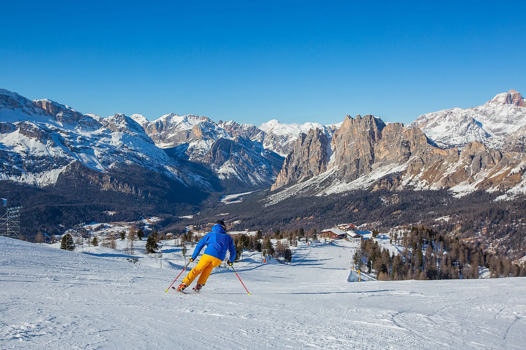 Skifahrer auf einer Piste in Cortina d’Ampezzo mit Blick auf die verschneiten Dolomiten in Venetien.