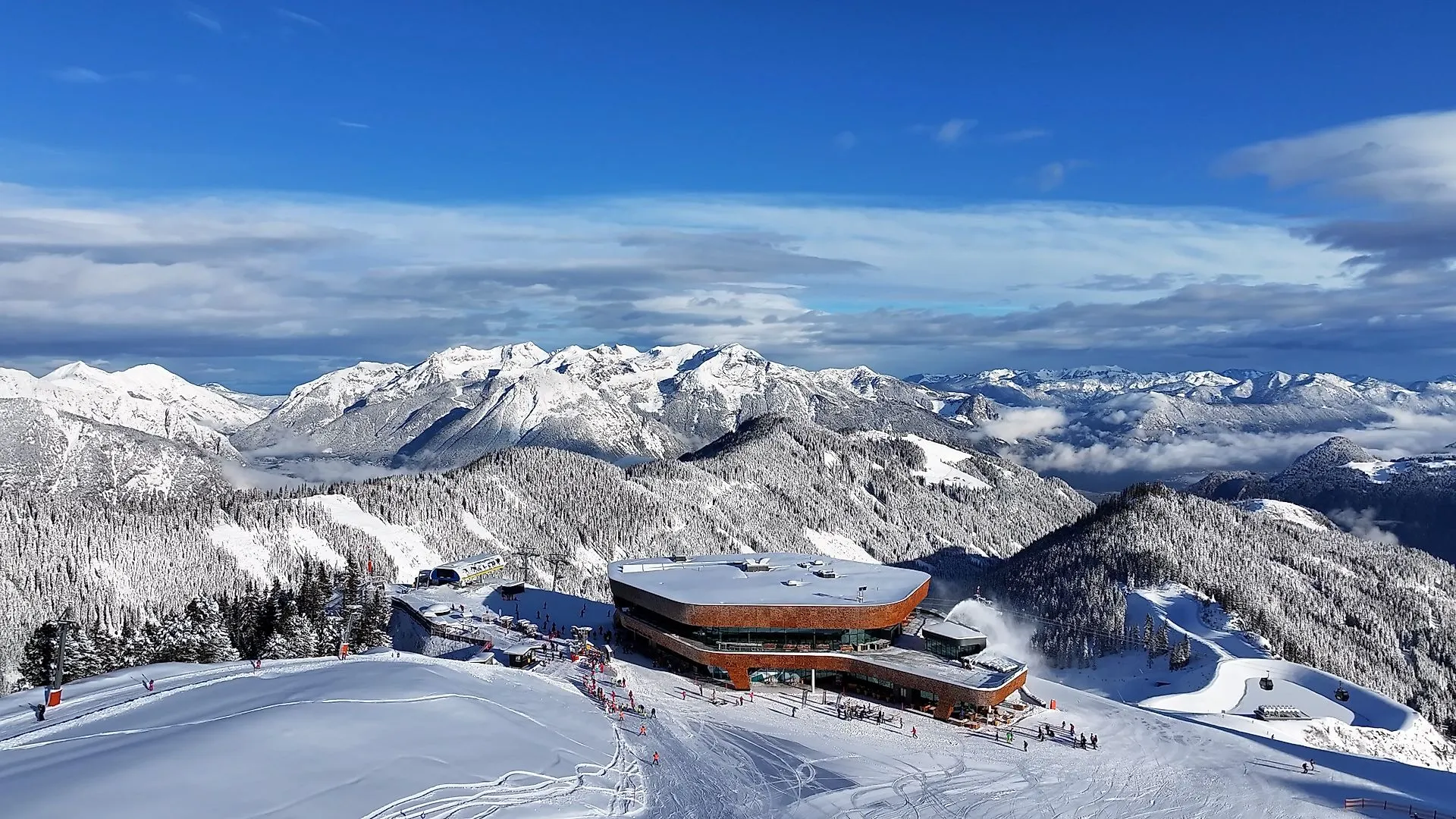 Luftaufnahme der idyllischen Winterlandschaft im Zillertal mit verschneiten Pisten und Skifahrern