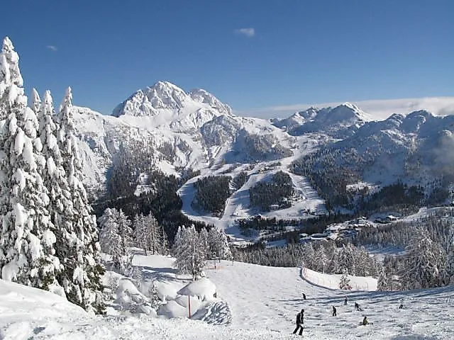 Skifahrer auf verschneiter Piste mit Blick auf das Winterpanorama bei Hermagor