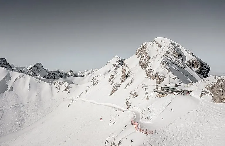 Groupe de skieurs devant un décor enneigé à la Videmanette à Rougemont avec vue sur des sommets marquants en hiver.