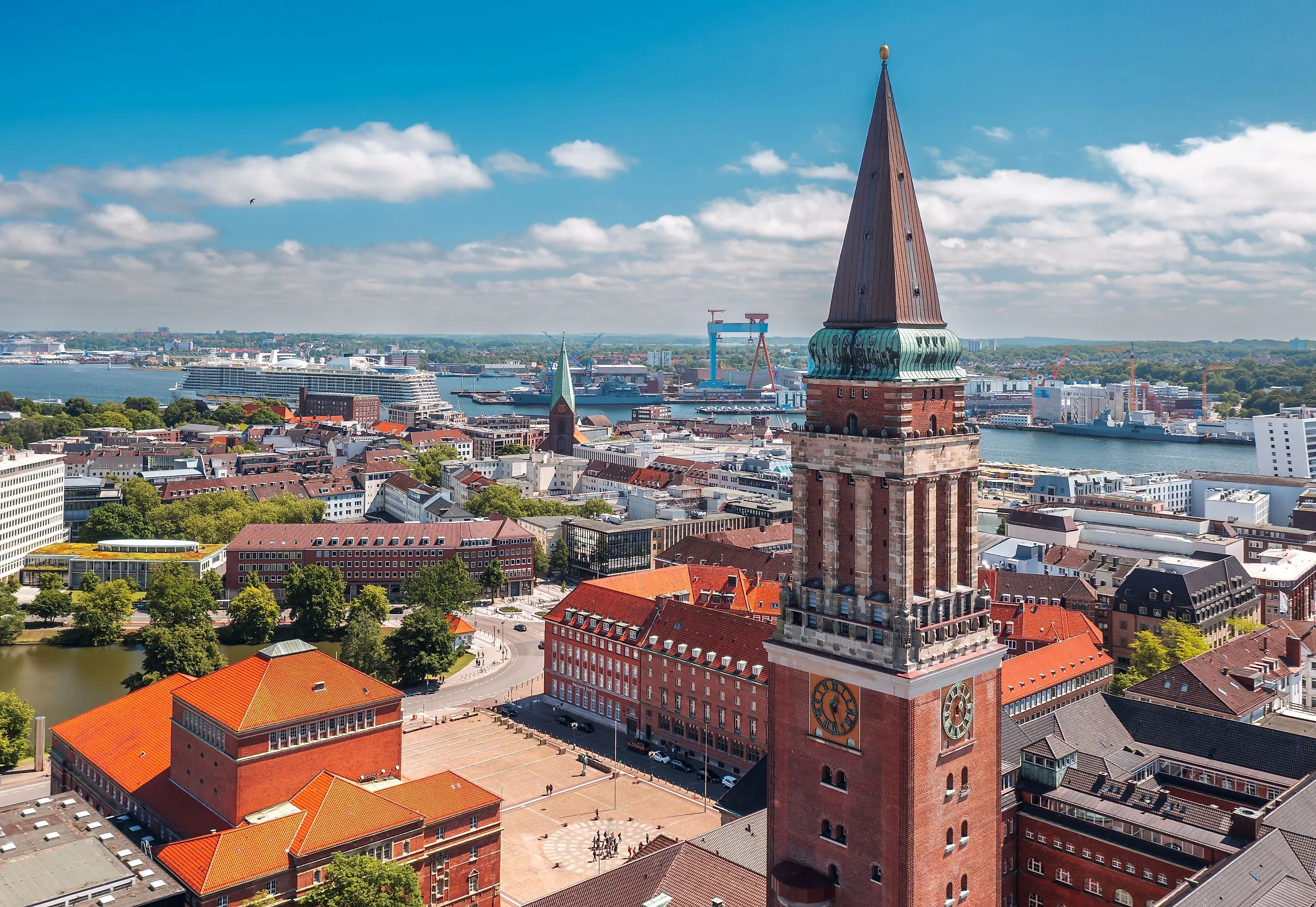 Kiel mit Rathaus und Hafen, Kreuzfahrtschiffen und Werften im Hintergrund