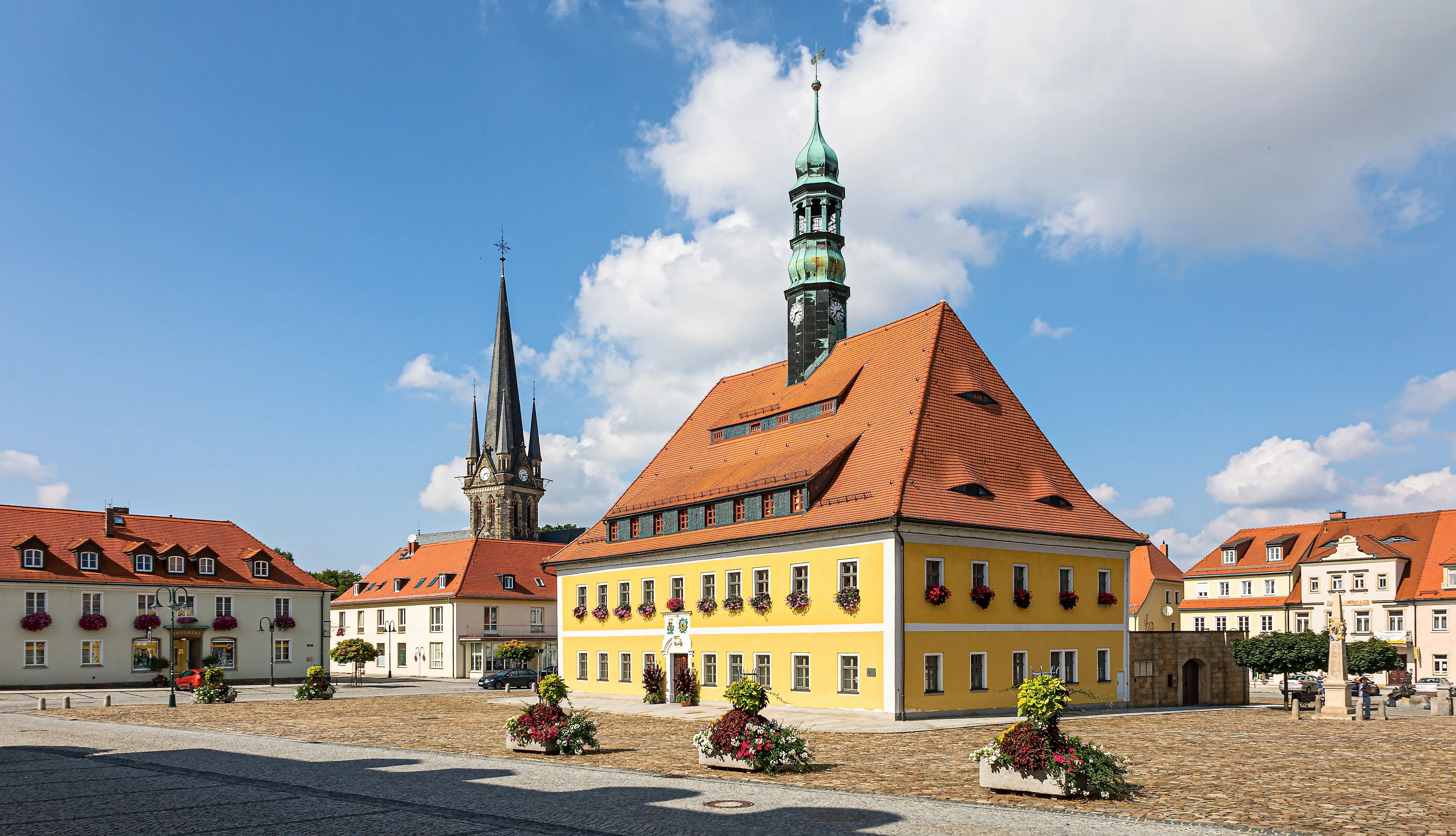 Historisch stadhuis in Neustadt in Saksen met bloemen en uitzicht op het marktplein