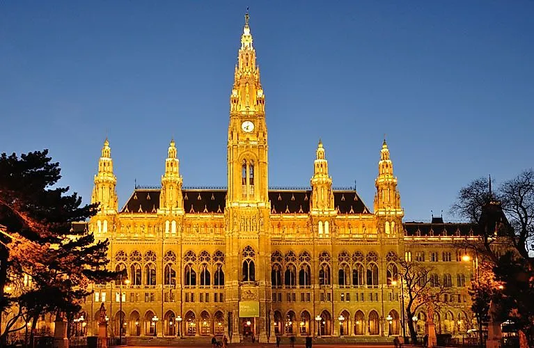 Beleuchtetes Wiener Rathaus im neugotischen Stil bei Abenddämmerung