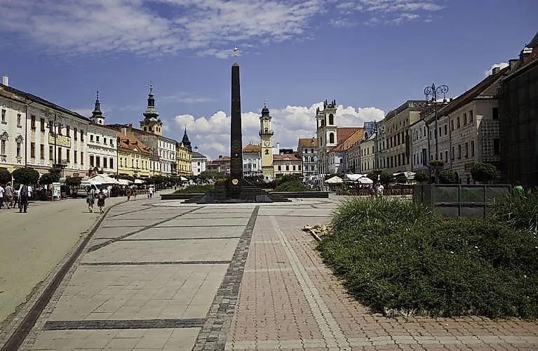 Zentraler Platz von Banská Bystrica mit Obelisk und historischen Gebäuden – Webcam zeigt das Stadtleben live