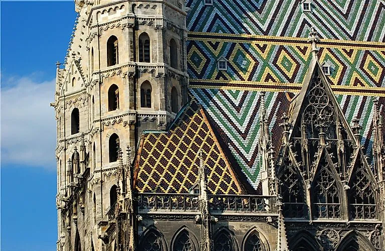 Detailansicht des Stephansdoms in Wien mit bunt gemustertem Ziegeldach und gotischer Fassade bei Tageslicht