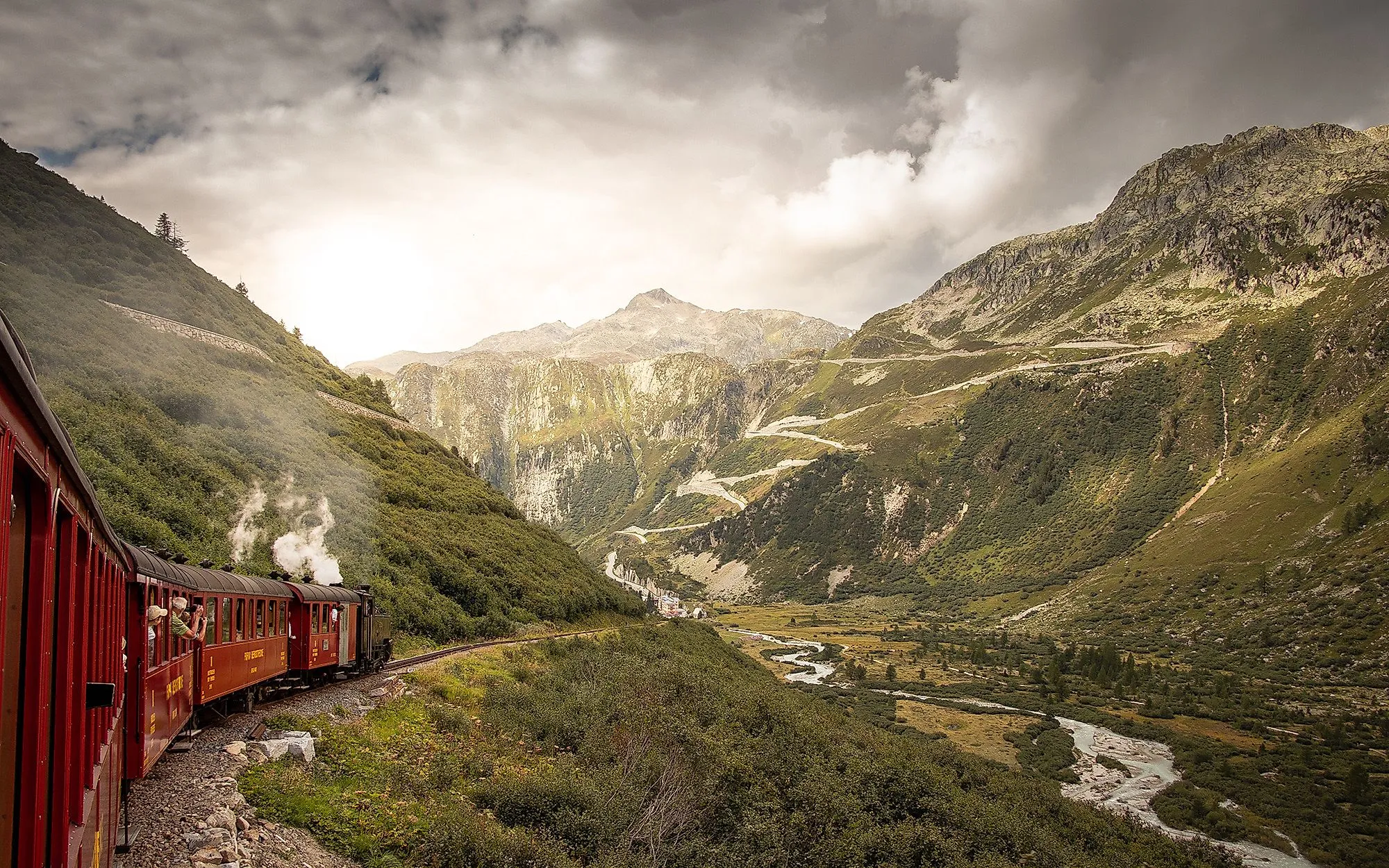 Historische Furka-Dampfbahn schlängelt sich durch das grüne Rhonetal im Wallis, umgeben von majestätischen Bergen